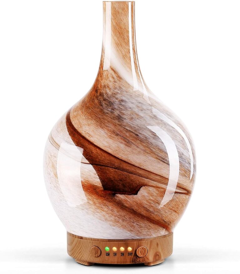 Handmade art glass aroma diffuser with a warm amber marble pattern on a wood grain base